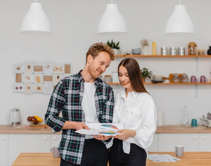 Couple comparing color palettes and finish samples while planning kitchen design trends