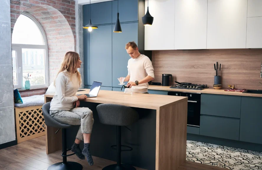 Couple in a remodeled kitchen with a wood island and pendant lighting