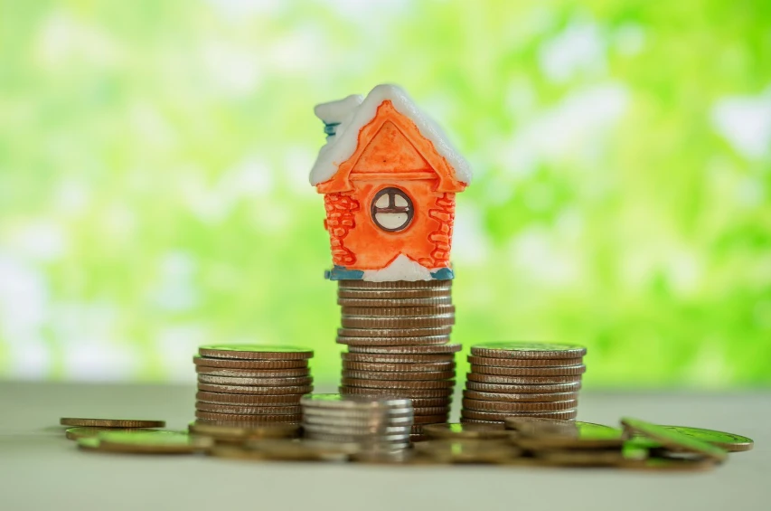 Miniature house on stacks of coins showing rental income growth from an accessory dwelling unit
