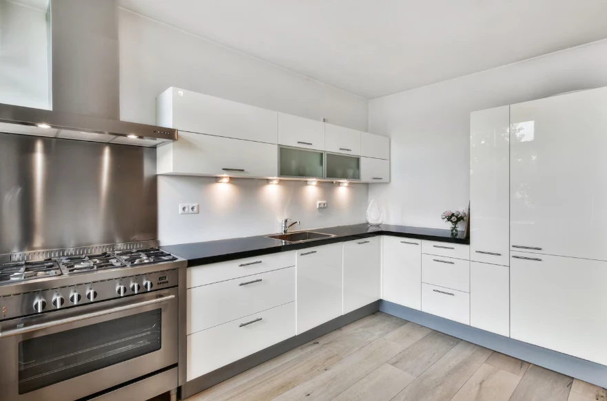 White gloss kitchen with stainless range and dark countertops budgeted for kitchen remodel cost in Los Angeles