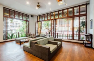 Bright sunroom style addition with folding glass doors and wood floors, a higher end room addition cost Los Angeles example