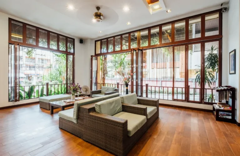 Bright sunroom style addition with folding glass doors and wood floors, a higher end room addition cost Los Angeles example